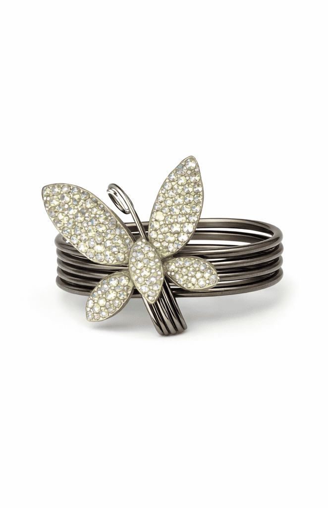 Silver ring with crystal embellishments and butterfly-shaped ring on a white background