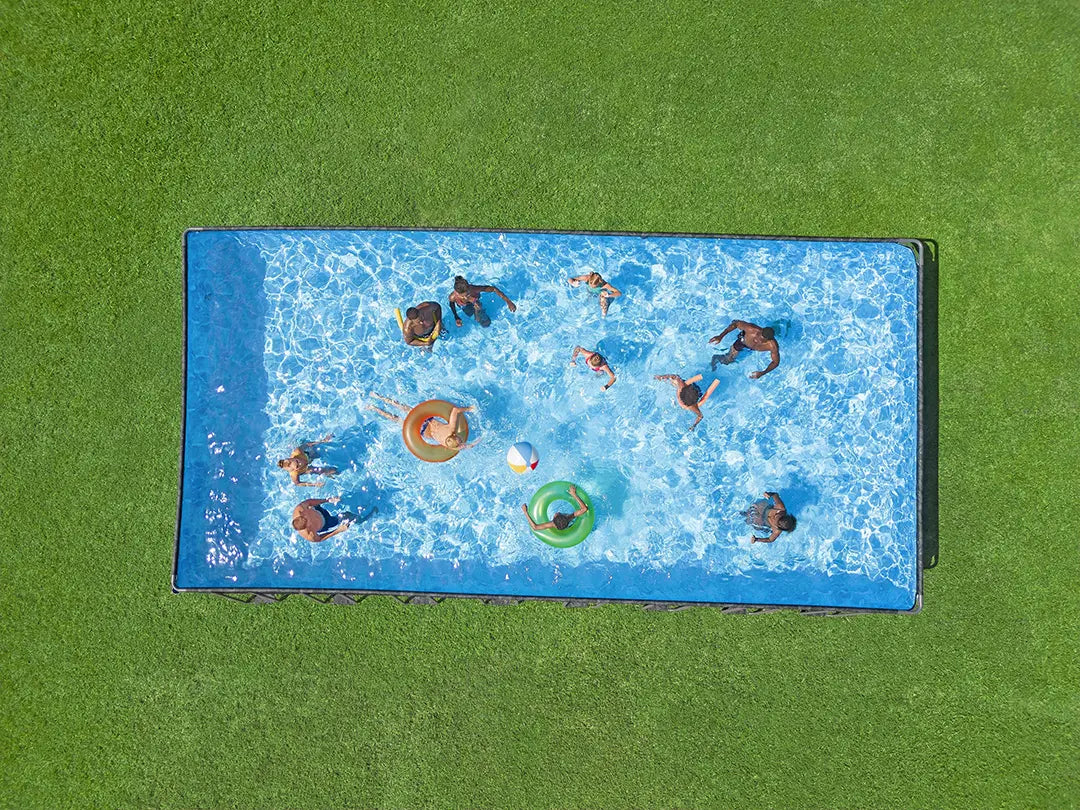 People swimming in a pool from an aerial perspective on a green grass pool for hire on event 